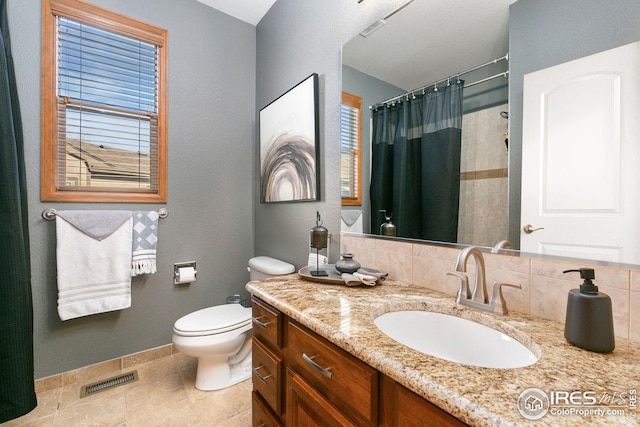 full bath featuring vanity, toilet, visible vents, baseboards, and tile patterned flooring