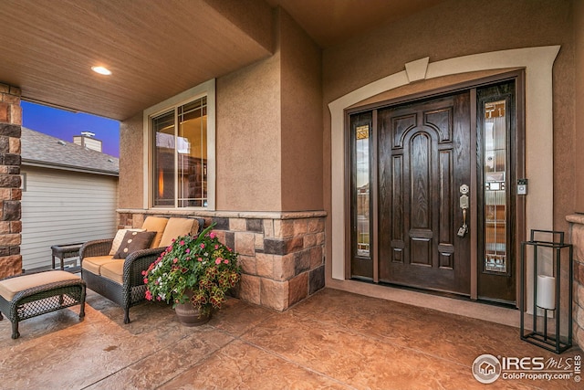 doorway to property featuring a porch and stucco siding