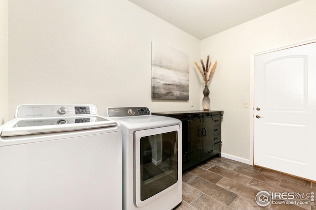 washroom with washer and dryer, laundry area, and baseboards