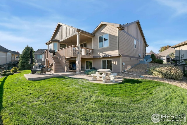 back of house with board and batten siding, stairway, a wooden deck, a patio area, and a lawn