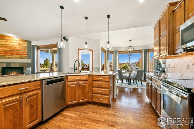 kitchen featuring stainless steel appliances, brown cabinets, and a sink