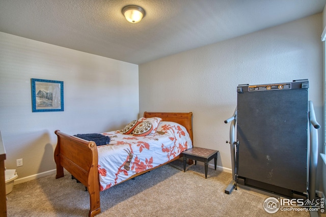 bedroom with a textured ceiling, carpet flooring, and baseboards