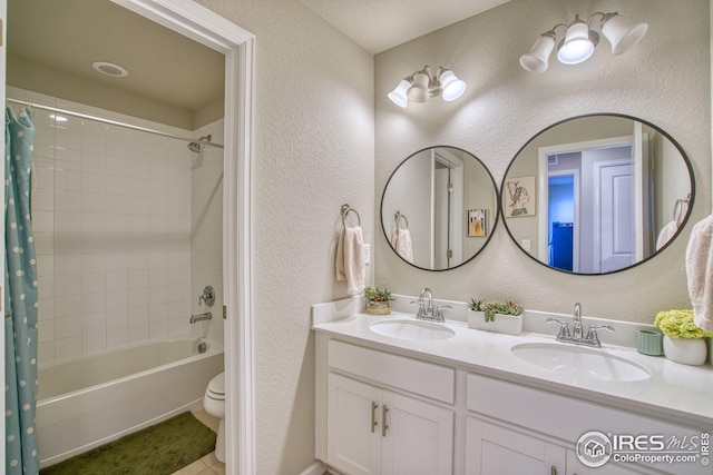 bathroom featuring a textured wall, a sink, and toilet