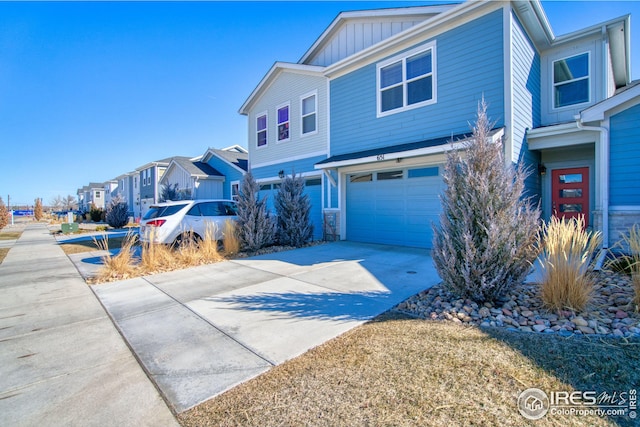 view of front of home with a garage, a residential view, board and batten siding, and concrete driveway