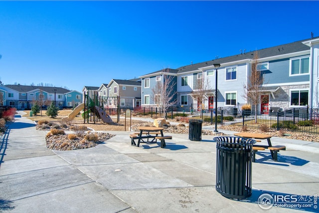 view of home's community with a residential view, fence, and playground community