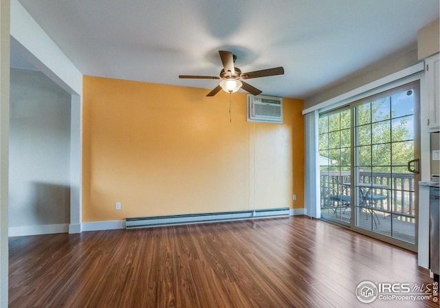 spare room with a baseboard radiator, baseboards, wood finished floors, and a wall mounted air conditioner