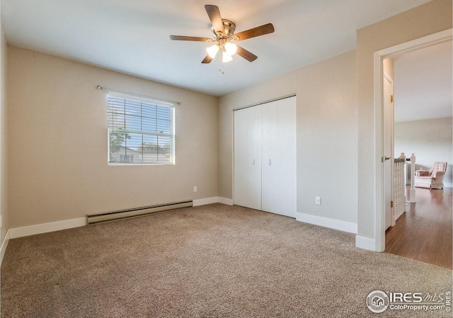 unfurnished bedroom with a baseboard heating unit, carpet flooring, and baseboards