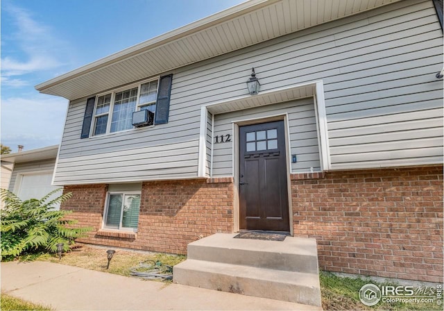 doorway to property with brick siding