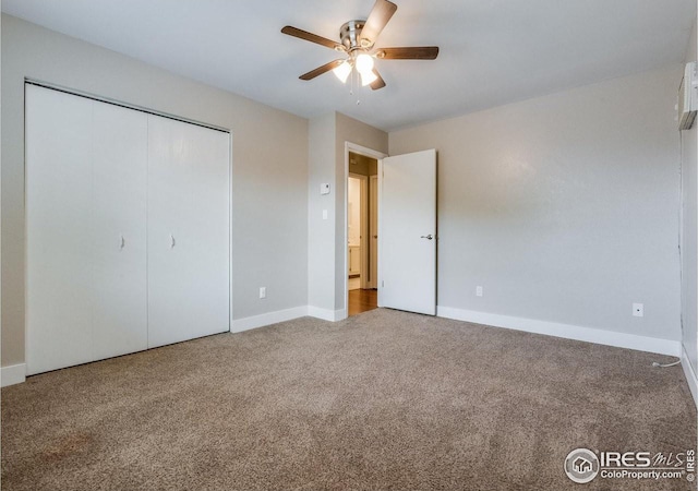 unfurnished bedroom with ceiling fan, a closet, baseboards, and carpet flooring