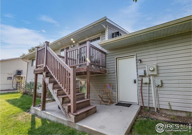 view of exterior entry featuring a deck and a lawn