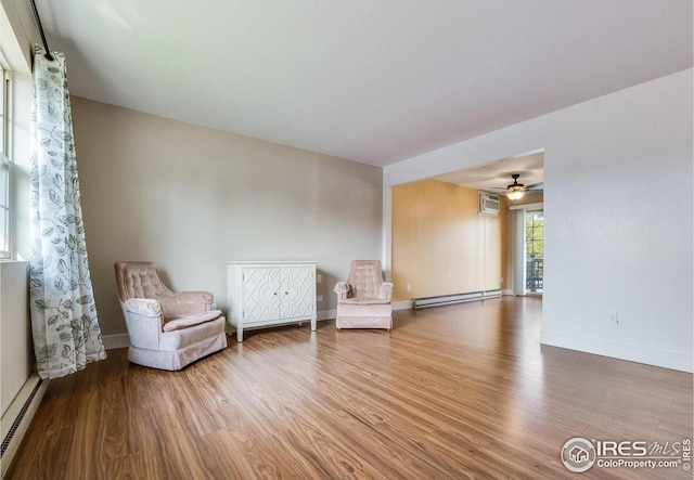 unfurnished room featuring baseboard heating, a baseboard radiator, wood finished floors, and baseboards