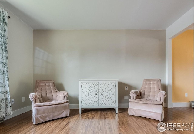 sitting room featuring baseboards and wood finished floors