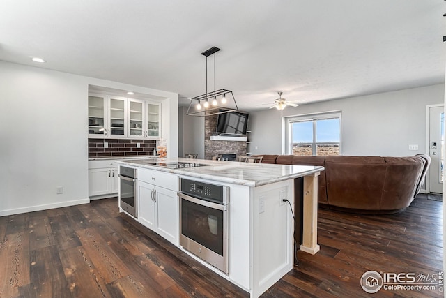 kitchen with open floor plan, oven, and ceiling fan