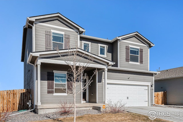 traditional-style home with a garage, fence, and concrete driveway