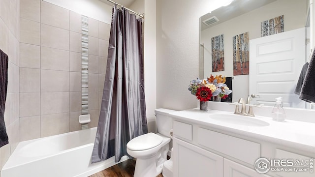 full bath with visible vents, a textured wall, toilet, shower / tub combo with curtain, and vanity