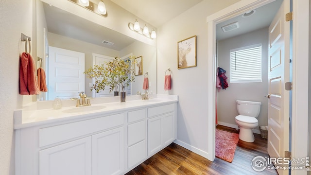 full bath featuring visible vents, a sink, and wood finished floors