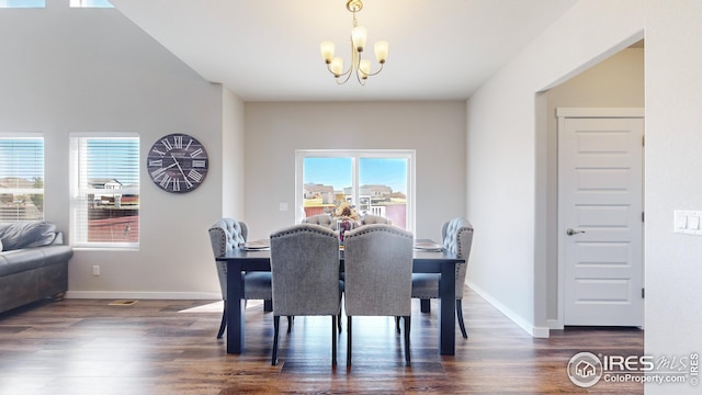 dining space featuring a chandelier, dark wood finished floors, and baseboards