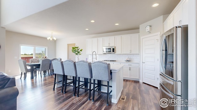 kitchen with decorative backsplash, dark wood-style flooring, stainless steel appliances, light countertops, and white cabinetry