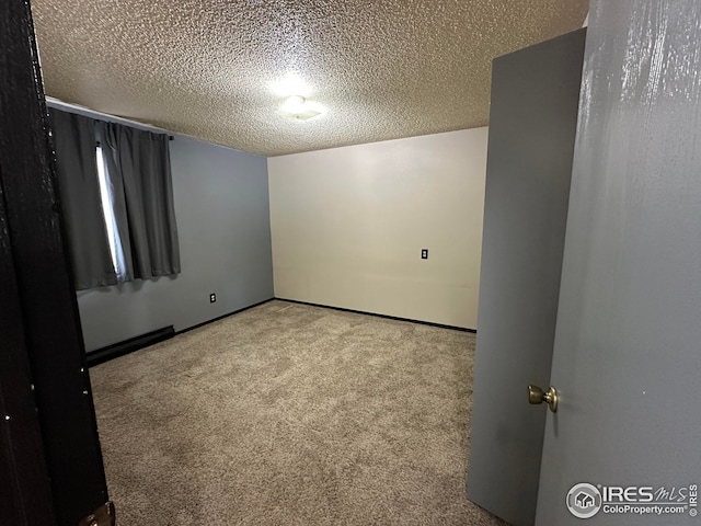 carpeted spare room with a textured ceiling