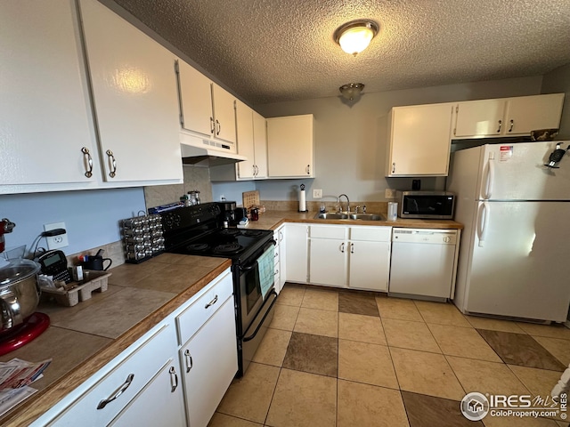 kitchen with white cabinetry, a sink, light tile patterned flooring, white appliances, and under cabinet range hood