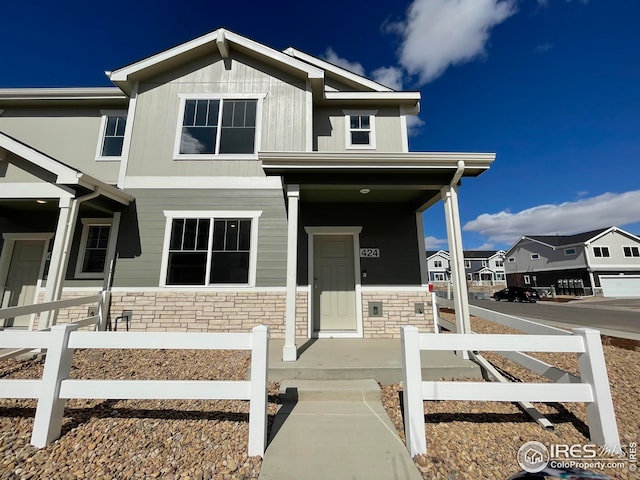 view of front of property with stone siding and fence