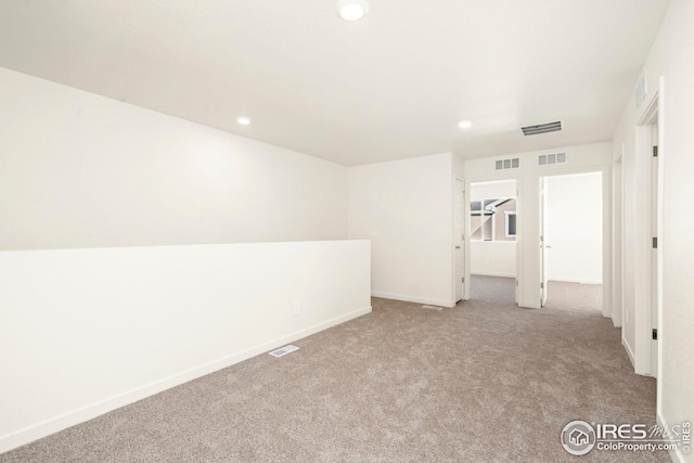 spare room featuring carpet floors, recessed lighting, and visible vents