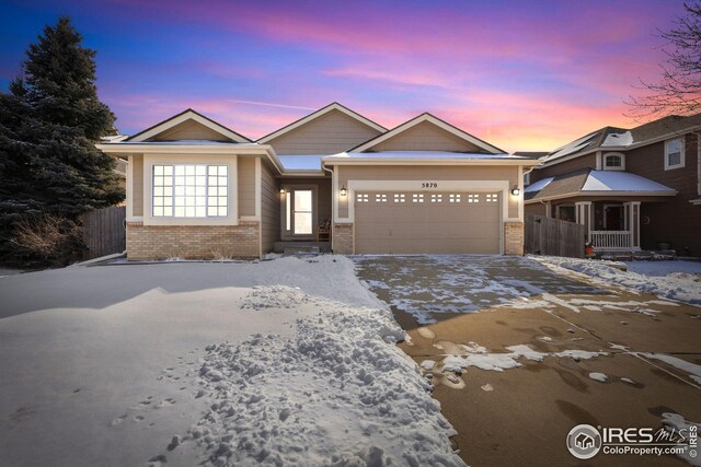 ranch-style house with a garage, concrete driveway, brick siding, and fence