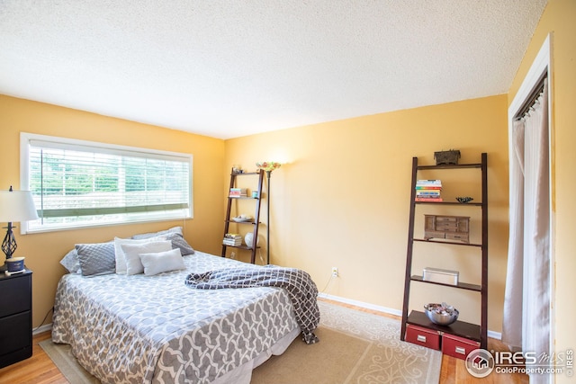 bedroom featuring baseboards and a textured ceiling