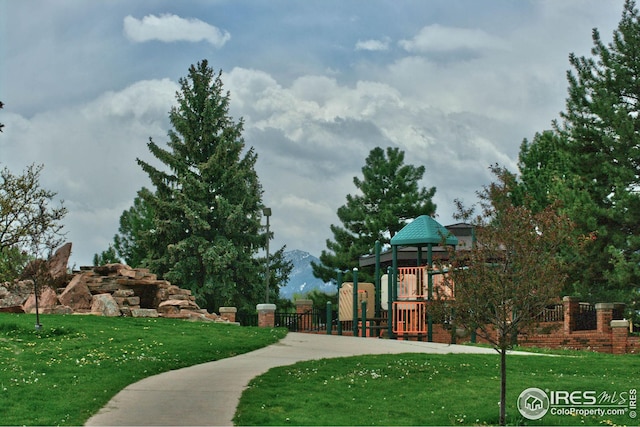 view of home's community with playground community, a yard, and a mountain view