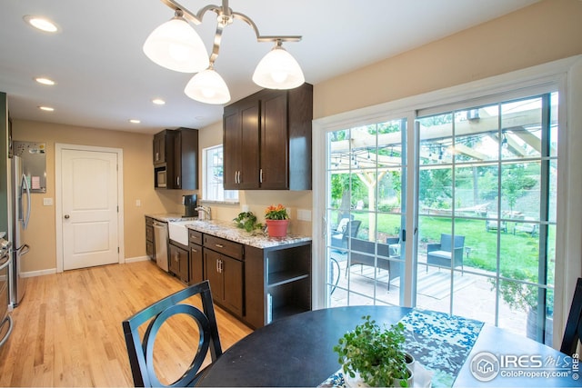 kitchen featuring light wood-style floors, freestanding refrigerator, dark brown cabinetry, and recessed lighting