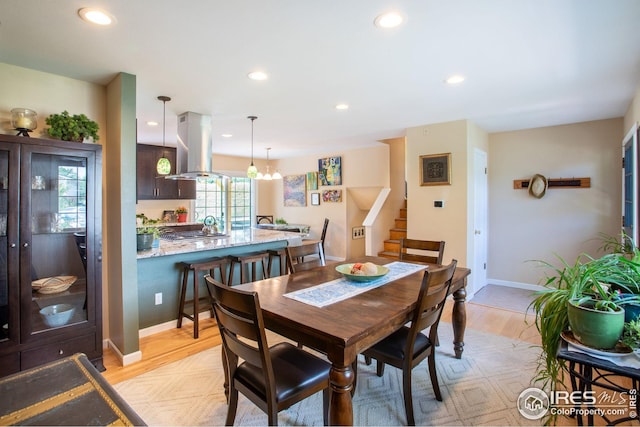 dining space with light wood-style floors, stairs, and recessed lighting