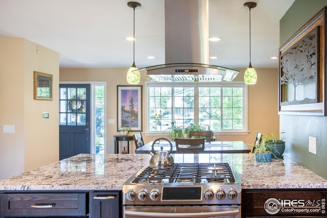 kitchen with stainless steel gas range, pendant lighting, island exhaust hood, and light stone counters