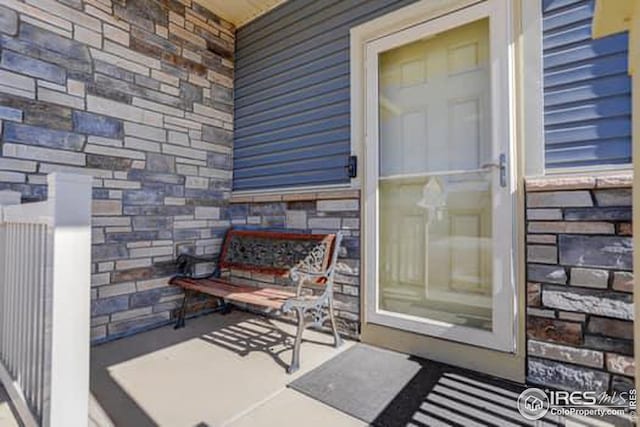 property entrance with stone siding