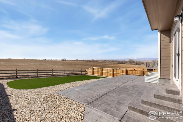 view of patio / terrace with a fenced backyard and a rural view