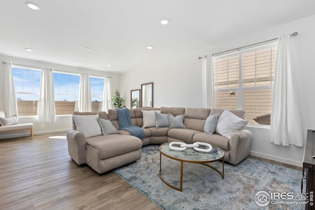 living area with baseboards, light wood finished floors, and recessed lighting