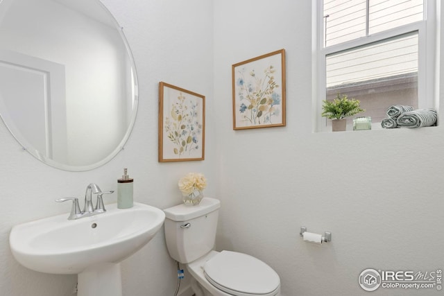 half bath with toilet and a sink
