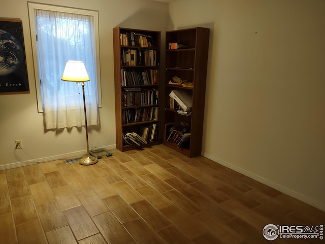 interior space featuring baseboards, visible vents, and wood tiled floor