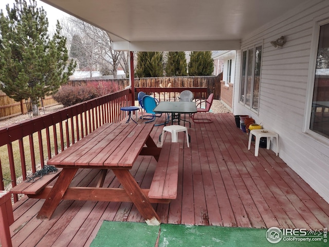 deck with outdoor dining area and fence