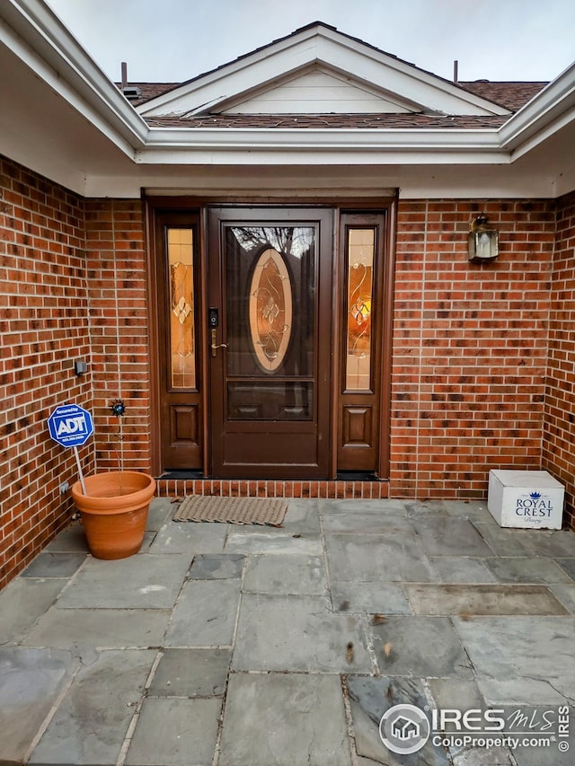 property entrance featuring brick siding