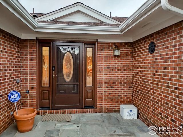 doorway to property featuring brick siding