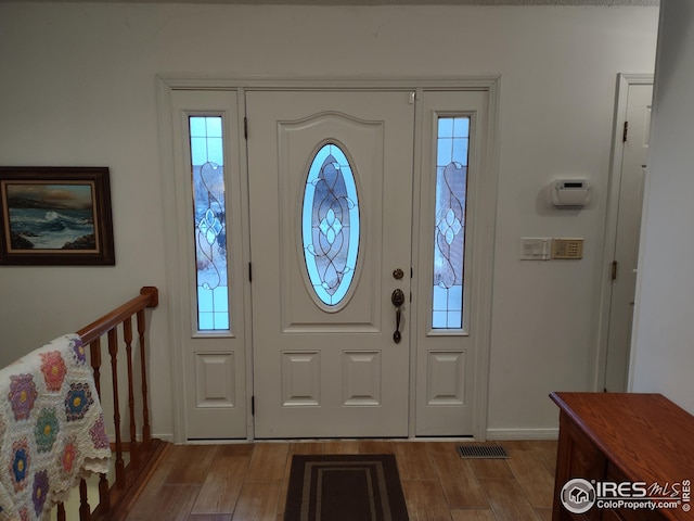 entrance foyer with baseboards and wood finished floors