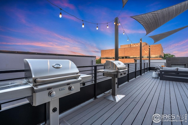 deck at dusk featuring grilling area