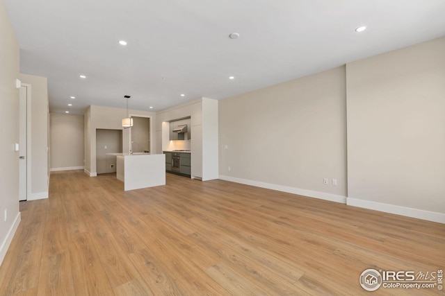 unfurnished living room featuring light wood-style flooring, baseboards, and recessed lighting