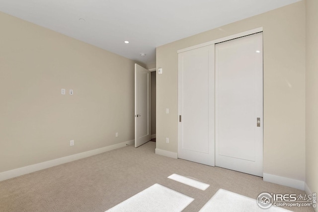 unfurnished bedroom with a closet, carpet, and baseboards