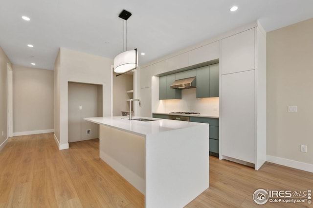 kitchen with light wood-style flooring, stainless steel gas cooktop, a sink, range hood, and modern cabinets