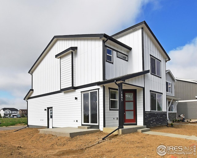 view of front of property featuring board and batten siding and a patio area