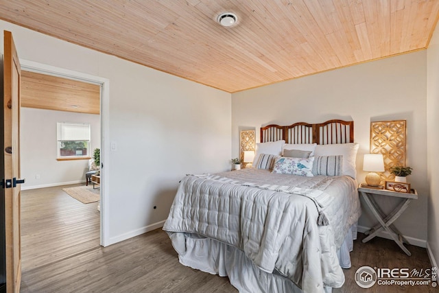 bedroom featuring wood ceiling, baseboards, and wood finished floors