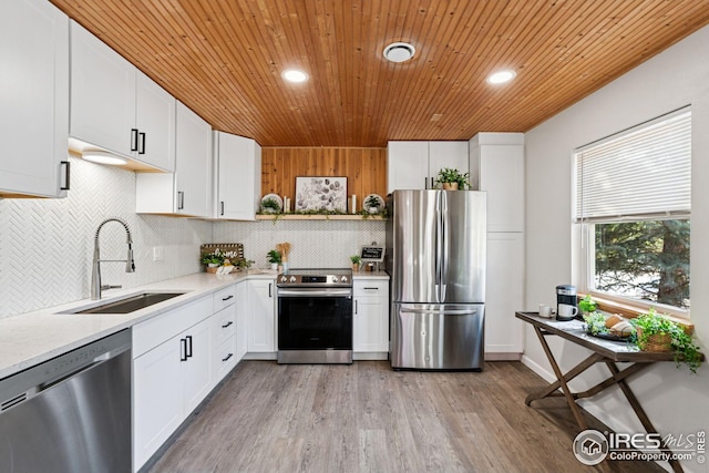 kitchen featuring decorative backsplash, appliances with stainless steel finishes, white cabinetry, a sink, and wooden ceiling