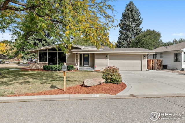 single story home featuring a garage, driveway, and a front lawn