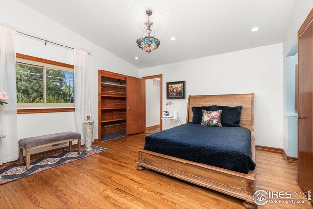 bedroom featuring lofted ceiling, light wood-type flooring, baseboards, and recessed lighting